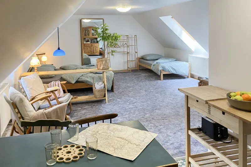 Obytný prostor podkrovního apartmánu se stolem na jídlo